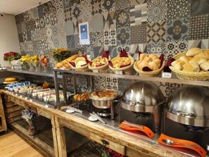 A buffet setup with various food items and utensils. - The Landmark Residence - Oficial (São Paulo)