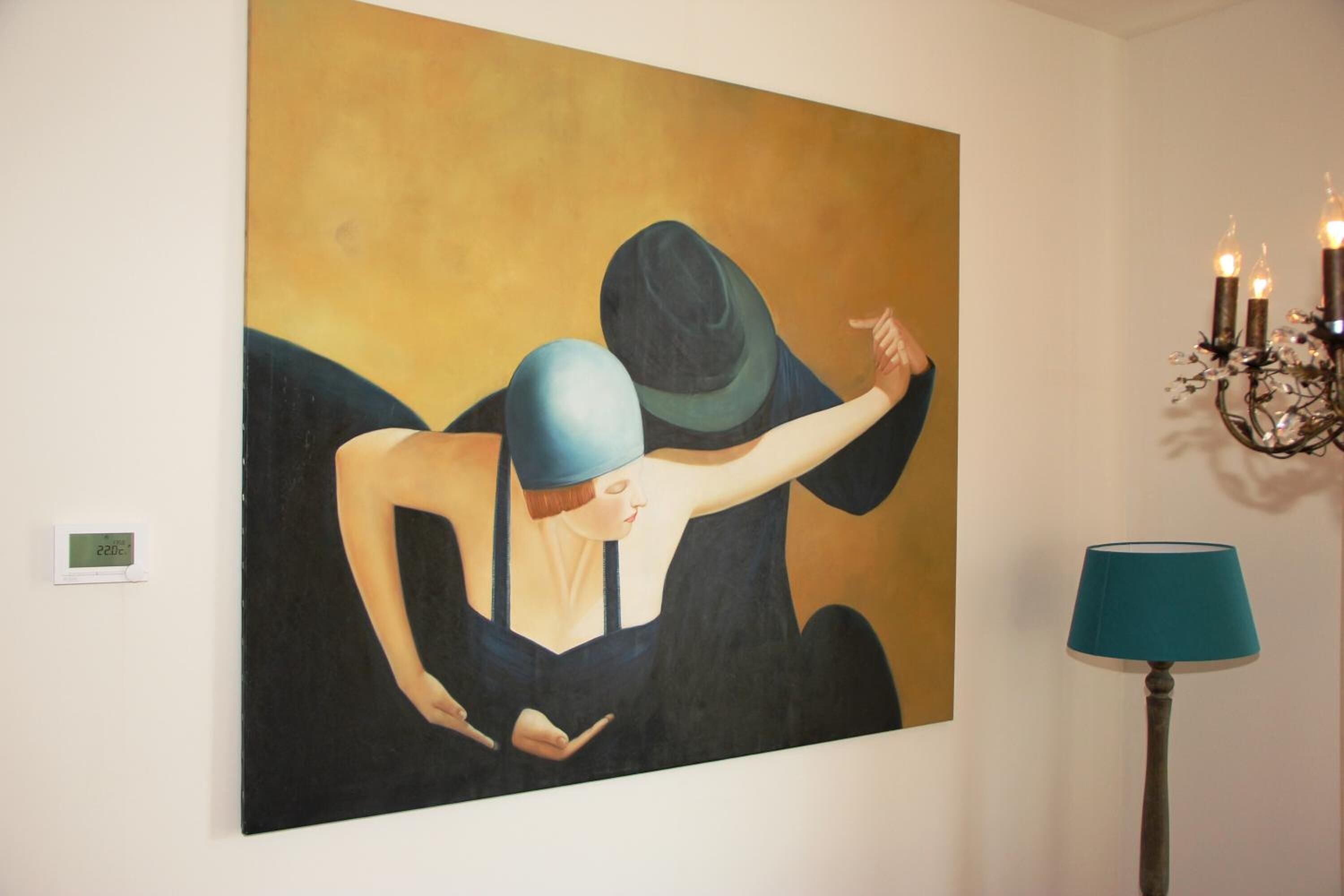 Ein Gemälde an der Wand, eine Lampe und ein Thermostat.
