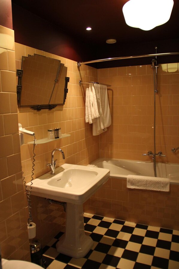 A bathroom with a sink, bathtub, and shower. - Augusta Hotel & Restaurant (IJmuiden)