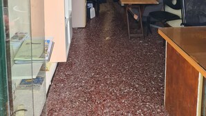 Une chambre d’hôtel compacte comprenant un coin cuisine, un espace repas, une grande fenêtre avec rideaux et un climatiseur fixé au mur.