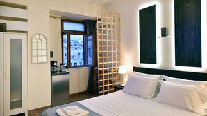 Une chambre d’hôtel avec un lit, un bureau, une armoire et une fenêtre donnant sur un paysage agréable.