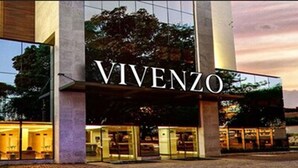 Un edificio moderno con el nombre 'VIVENZO' visible en letras grandes.