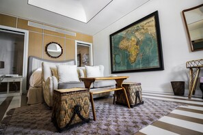 A modern bedroom with a bed, a side table, a map on the wall, and a large window.