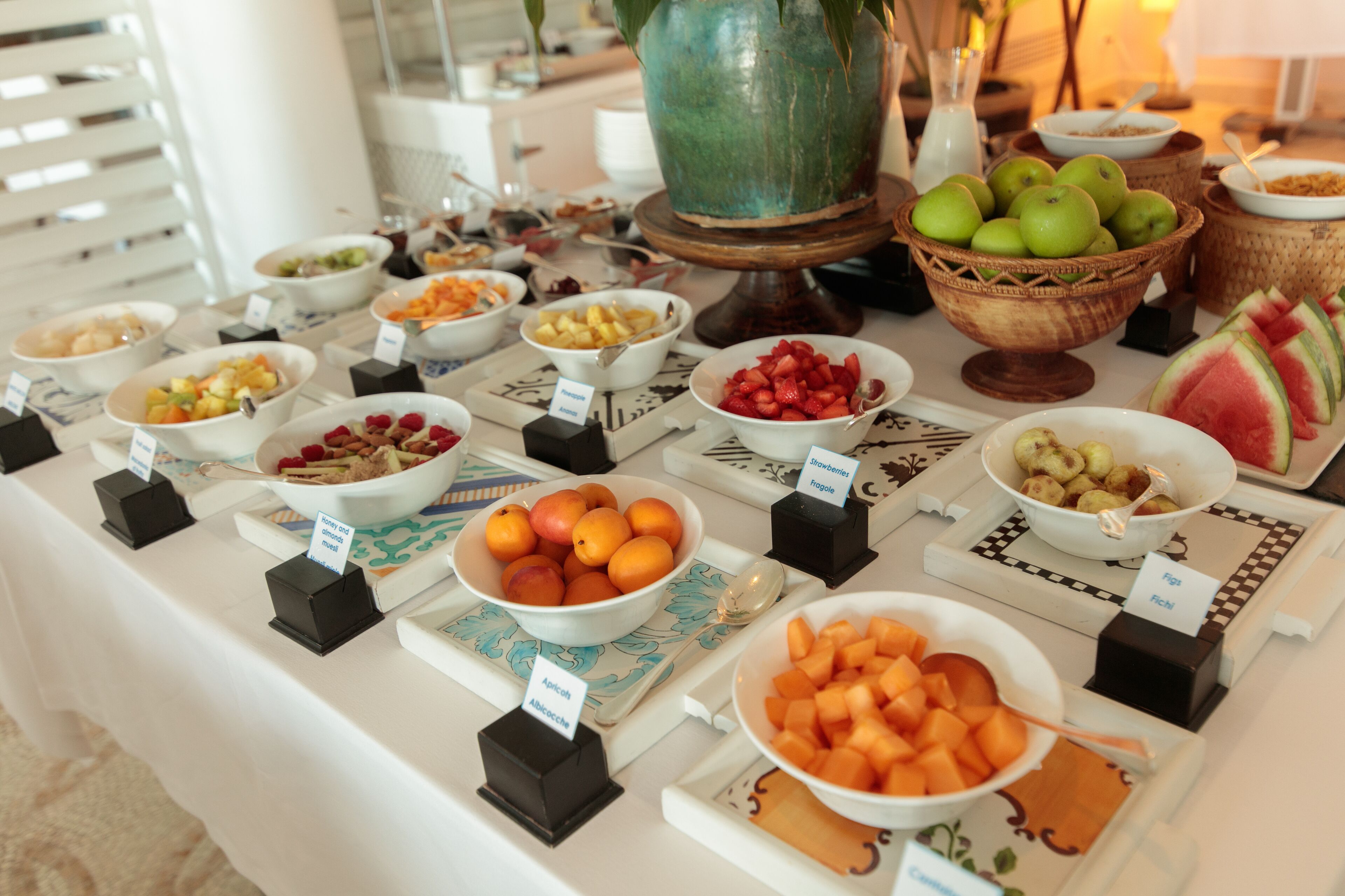 A buffet table with various fruits and dishes.