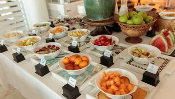A buffet table with various fruits and dishes.