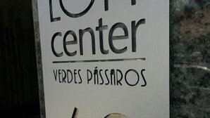A sign with the text 'LOFT center' and 'VERDES PASSAROS 62'. - Loft Center Verdes Pássaros (Porto Alegre)