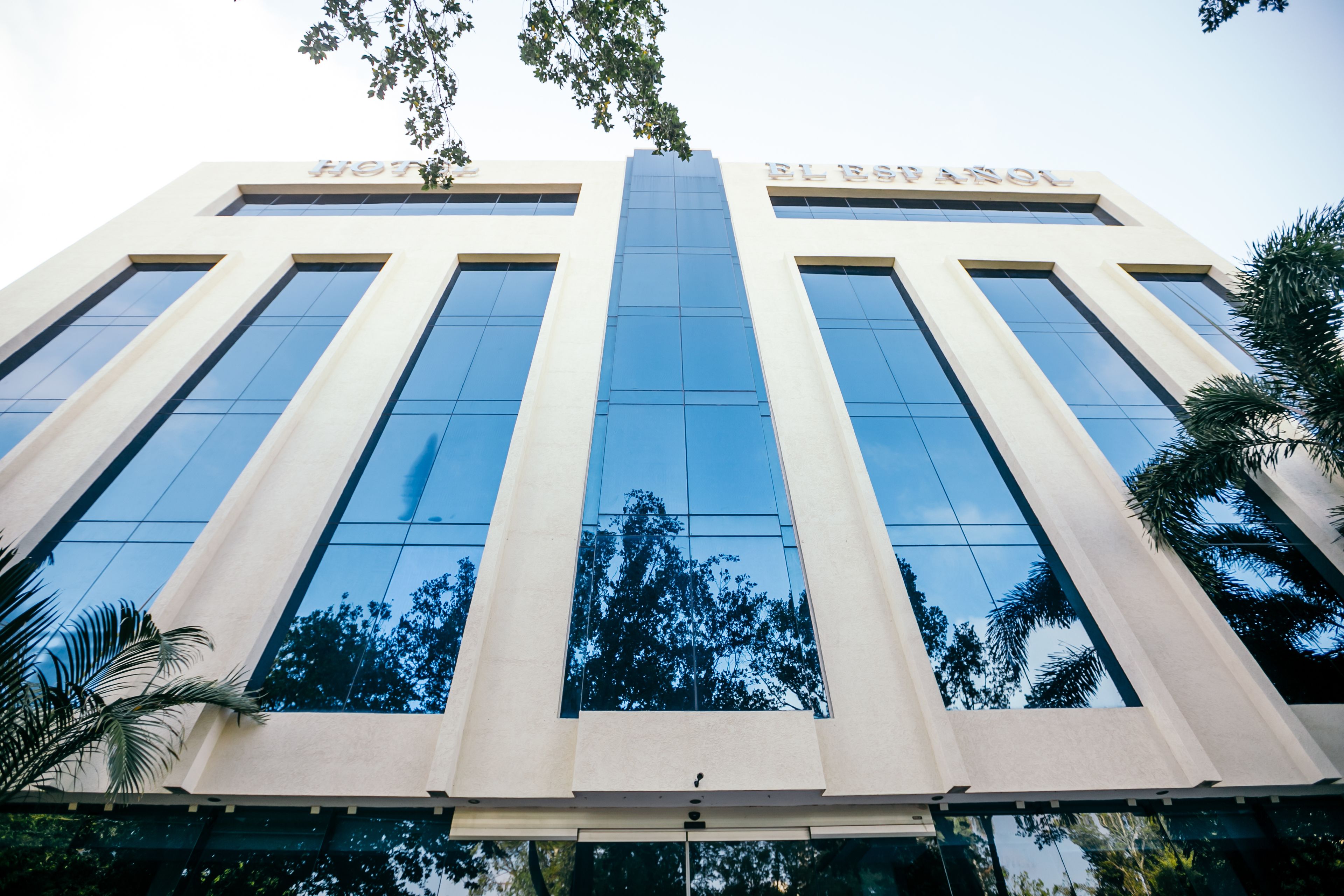A modern hotel building with a reflective glass facade and a central entrance.
