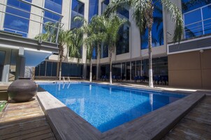 Una piscina al aire libre, sillones reclinables de piscina