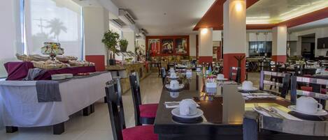 A spacious dining area with long tables, chairs, and a buffet setup.