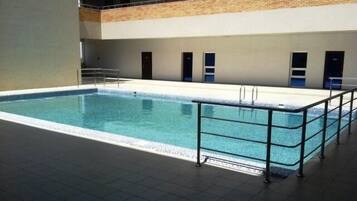 Alberca al aire libre y camastros