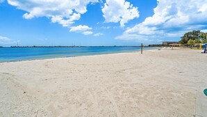 Une plage avec un ciel dégagé et une mer calme.