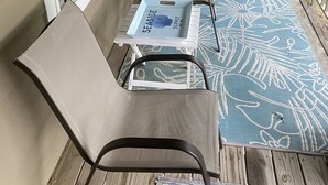 Un espace extérieur aménagé, abrité et doté de chaises, d’une table et d’un mur décoratif.