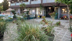 A modern hotel with a pool, outdoor seating, and a garden area. - Akcay Zeytin Otel (Edremit)