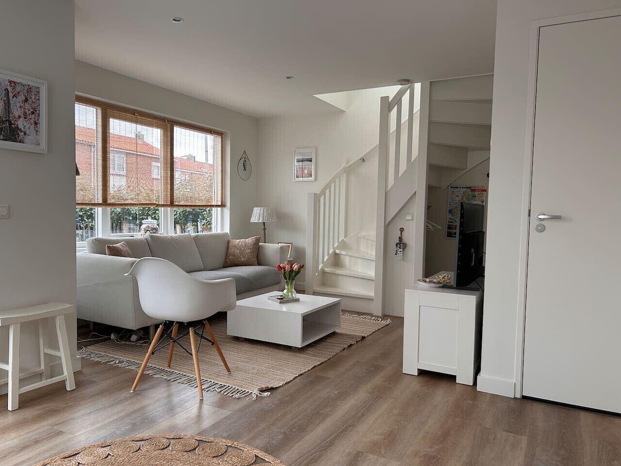 A modern living room with a sofa, coffee table, and a staircase leading to another level.