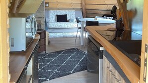 Een interieur met een keukenhoek, een eettafel en een bank.