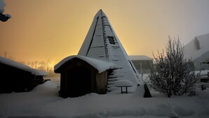 Een gebouw met een sneeuwend dak, omringd door sneeuw.