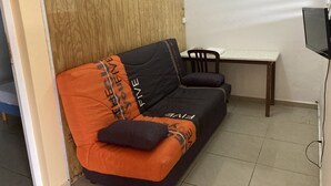 Un espace de vie compact comprenant un canapé, une petite table et une chaise.