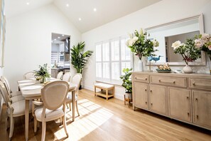 A modern kitchen with a dining area, wooden cabinets, and potted plants. - 2 short blocks  to the beach. FULLY RENOVATED HOUSE  WITH NEW HOT TUB. (Point Pleasant Beach)