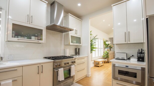 A modern kitchen with stainless steel appliances, white cabinetry, and a central island.