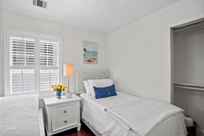A bedroom with a bed, nightstand, lamp, and a painting on the wall. - 2 short blocks  to the beach. FULLY RENOVATED HOUSE  WITH NEW HOT TUB. (Point Pleasant Beach)