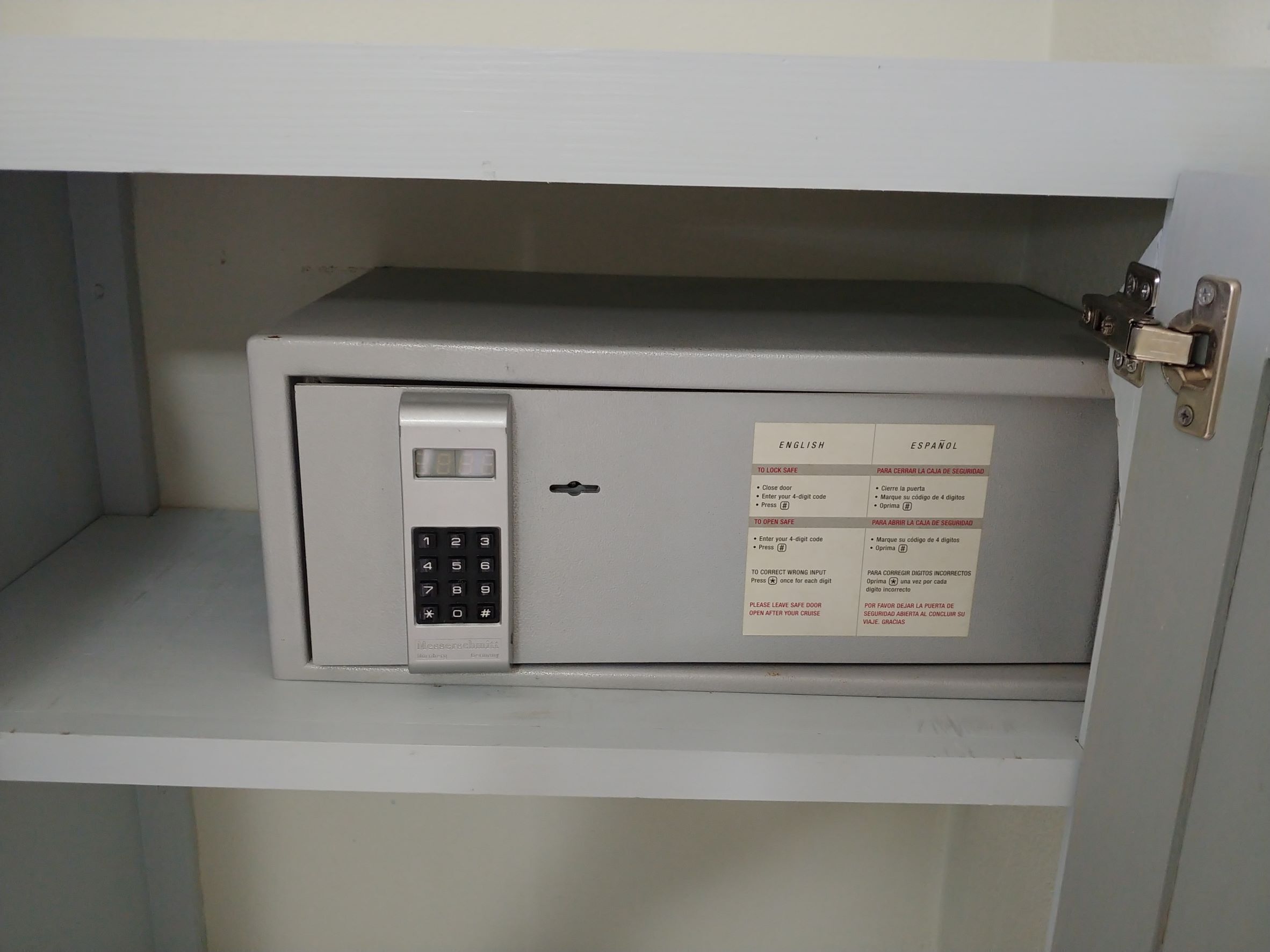 A safe with a keypad and a lock mechanism, accompanied by a bilingual instruction label.