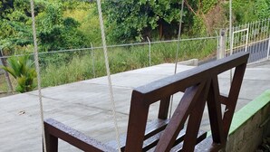 A wooden bench with metal railings, positioned on a tiled patio with a concrete edge. - 1 Modern A/C apartment with pool. Walking distance from beach, shop & restaurant (Castries)