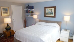 A hotel room with a large bed, two bedside lamps, a bookshelf, and two framed pictures on the wall. - Architect designed 1-bdrm/+wall-bed, 15-min walk to downtown, Patio/balcony/View (Estes Park)