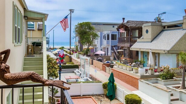 Eine Wohngegend an der Küste mit Häusern, einer Terrasse und Gartenmöbeln sowie einer amerikanischen Flagge.