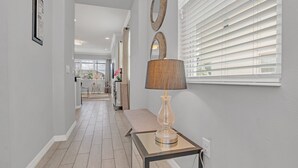 Ein Flur mit einer Lampe, einer Bank und einem gerahmten Bild an der Wand.