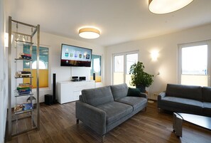 Relax in this stylish living room with a sofa, coffee table, and flat-screen TV.