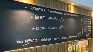 Quadro negro com cardápio exibindo itens como 'Buffet' e 'Keitto', juntamente com os preços.