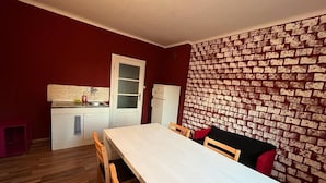 Une cuisine de taille réduite, dotée d’un plan de travail blanc, d’un évier et d’un réfrigérateur.
