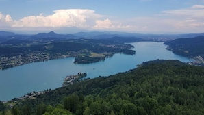 Une vue panoramique d’un lac entouré de collines boisées et d’une petite ville.