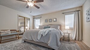 A bedroom with a bed, a bedside table, a mirror, and a ceiling fan. - Golf Lover's Getaway! Cozy 2BR/2BA Townhome, Walk to DeSoto Golf Club! (Hot Springs)