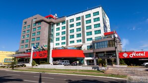 A hotel with multiple floors, a red and white facade, and a parking area in front. - Grand Park Hotel (Campo Grande)