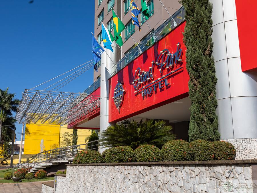 A hotel with a prominent red sign, multiple flags, and a modern architectural design.