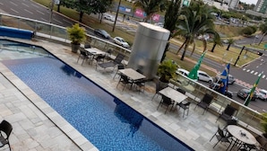 A rooftop pool with a view of the cityscape, including palm trees and a road. - Grand Park Hotel (Campo Grande)