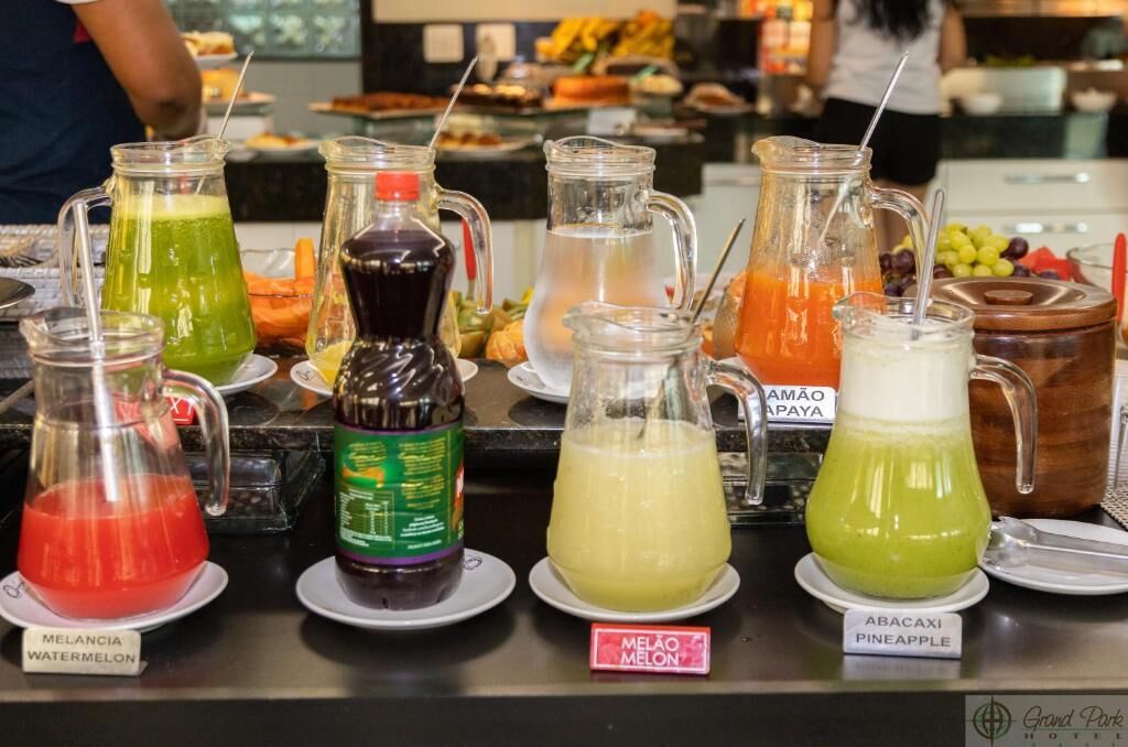 Eine Getränkestation mit verschiedenen Getränken, beschriftet mit Melancia Wassermelone, Melão Melone und Abacaxi Ananas.
