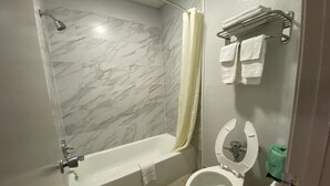 A bathroom with a bathtub, toilet, and shower. - Scottish Inns Jonesboro AR  (Jonesboro)