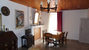 Ein Essbereich mit Holztisch, Stühlen, einem Fernseher und einem Kamin.
