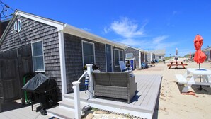 Eine Reihe Strandhäuser mit Außenbestuhlung und Grillplatz.
