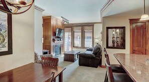 Relax in this inviting living room with a dining area, featuring a sofa, coffee table, and dining table with chairs.