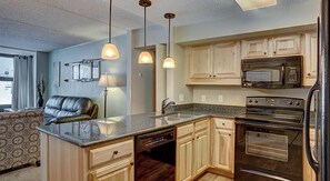 Enjoy cooking in this well-equipped kitchen with a central island, dishwasher, stove, microwave, and oven.