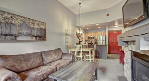 Relax in this stylish living space with a leather sofa, dining area, and modern kitchen.