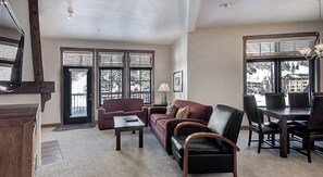 Relax in this stylish living area with a large window, sofa, and dining table.