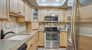 Enjoy cooking in this well-equipped kitchen with a microwave, double oven, and stainless steel range hood.
