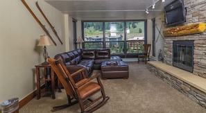 Relax in this cozy living space with a large sectional sofa and a comfortable wooden rocking chair.