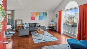 A modern living room with a sofa, coffee table, and artwork on the wall. - Executive Condo - Gigabit Wi-Fi - Near Redstone Arsenal - 2 beds-2 baths (Madison)