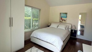 A bedroom with a bed, a wardrobe, a window with blinds, a painting on the wall, and a mirror. - SWISS 24 - Lake Stephanie (Clermont)