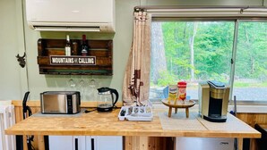 A kitchen with a wooden countertop, a toaster, a coffee maker, a kettle, and a window with a view of trees. - Romantic Cabin, Mnt View, Perfect Location ❤️ (Gatlinburg)